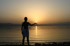 mulher com por do sol ao fundo