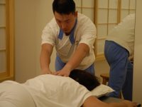 pessoa deitada recebendo massagem shiatsu