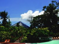 Foto do Tabacón Grand Spa Thermal Resort, na Costa Rica. A foto mostra uma casa rodeada de árvores e muito verde