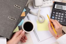 xícara de café telefone e caderno de anotações