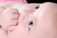 bebe com a mão na boca