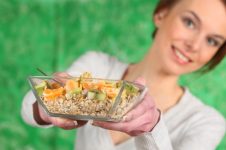 mulher segurando um pote de alimentos saudáveis a TPM